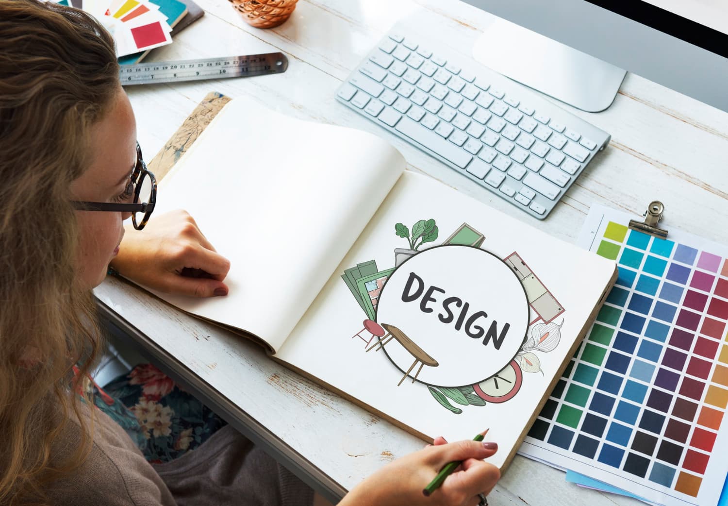 Designer sketching with color swatches on a desk